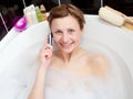 Beautiful woman talking on phone in a bubble bath Royalty Free Stock Photo