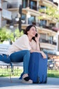 Beautiful woman talking on phone outside with luggage Royalty Free Stock Photo