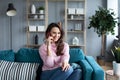 Beautiful woman talking on the phone while sitting on the sofa at home Royalty Free Stock Photo