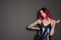 Beautiful woman with tattoos on arms against background. Space for text