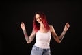 Beautiful woman with tattoos on arms against background