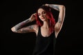 Beautiful woman with tattoos on arms against background