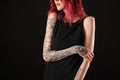 Beautiful woman with tattoos on arms against background, closeup