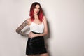 Beautiful woman with tattoos on arms against background