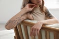 Beautiful woman with tattoos on arms resting indoors