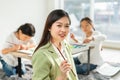 beautiful woman teacher smile, happy, look at camera, hold color paintbrush in education classroom. asian beautiful children happy Royalty Free Stock Photo