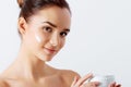 Beautiful woman tender jar of moisturizer cream. Close-up fresh young woman face. Royalty Free Stock Photo