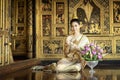 A beautiful woman in Thai national costume during the Ayuthaya period was sitting on a string of garlands. And smile beautifully Royalty Free Stock Photo