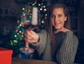 Beautiful woman toasting with red wine. Selective focus. Christmas lights in the background Royalty Free Stock Photo