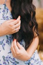 Beautiful woman are touching by her hand`s long, black and curly hair Royalty Free Stock Photo