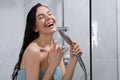 Beautiful woman with towel singing while taking shower Royalty Free Stock Photo