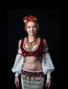 Woman in traditional folk slavic costume for belly dance and trible with circlet of flowers, vest, skirt, sleeves and necklace sta