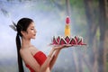 Beautiful woman in traditional Thai red dress holding krathong flower in her hands in loy krathong day concept Royalty Free Stock Photo