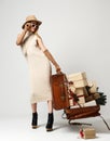 Beautiful woman traveler in hat with big open leather retro bag full of christmas present gifts Royalty Free Stock Photo