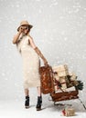 Beautiful woman traveler in hat with big open leather retro bag full of christmas present gifts Royalty Free Stock Photo