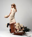 Beautiful woman traveler in hat with big open leather retro bag full of christmas present gifts surprised Royalty Free Stock Photo