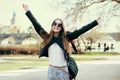 Beautiful woman traveling in Europe and walking on park in Prague. Girl having fund and holding hands up outdoors