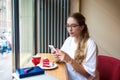 Beautiful woman in trendy glasses checking e-mail on mobile phone Royalty Free Stock Photo