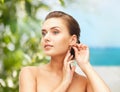 Beautiful woman trying on gold earrings