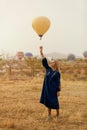 Beautiful Woman Trying To Reach Hot Air Balloon In Sky With Hand Royalty Free Stock Photo