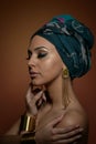 Beautiful woman with turban. Young attractive female with turban and golden accessories. Beauty fashionable woman Royalty Free Stock Photo