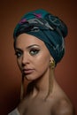 Beautiful woman with turban. Young attractive female with turban and golden accessories. Beauty fashionable woman Royalty Free Stock Photo