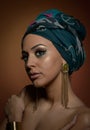 Beautiful woman with turban. Young attractive female with turban and golden accessories. Beauty fashionable woman