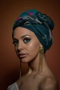 Beautiful woman with turban. Young attractive female with turban and golden accessories. Beauty fashionable woman
