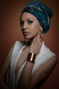 Beautiful woman with turban. Young attractive female with turban and golden accessories. Beauty fashionable woman