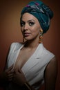 Beautiful woman with turban. Young attractive female with turban and golden accessories. Beauty fashionable woman