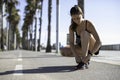 Beautiful woman tying shoes on a bike lane in Barcelona beach & x28;SPAIN