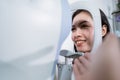 A beautiful woman is undergoing an examination using an eye examiner