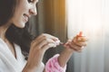 Beautiful woman use red color nail polish for painting her beautiful manicure in the morning at home with smiley face. Charming be Royalty Free Stock Photo