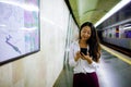 Beautiful woman using her cell phone on subway platform. Royalty Free Stock Photo