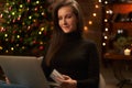 Beautiful woman using laptop computer, doing Christmas online shopping at home, paying with credit card Royalty Free Stock Photo