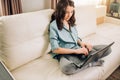 Beautiful woman using laptop computer at home on sofa Royalty Free Stock Photo