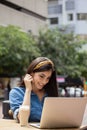 Beautiful woman using laptop while sitting at sidewalk cafe Royalty Free Stock Photo