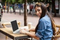 Beautiful woman using laptop while sitting at sidewalk cafe Royalty Free Stock Photo