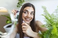 Beautiful woman using mascara on eyelash in bathroom in the morning time. Smiling young woman applying eye make up and looking at Royalty Free Stock Photo