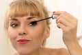 Beautiful woman using mascara eyeliner Royalty Free Stock Photo