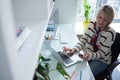 Woman using mobile phone and laptop at table Royalty Free Stock Photo