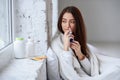 Beautiful woman using nasal spray. Close up of female feeling sick nose using sinus medication for blocked nose Royalty Free Stock Photo