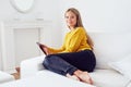 Beautiful woman using tablet sitting on sofa at home Royalty Free Stock Photo