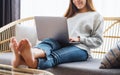 A young woman using and working on laptop computer while lying on a sofa at home Royalty Free Stock Photo