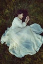 Beautiful woman with victorian dress on a bed of grass Royalty Free Stock Photo