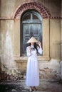 A beautiful woman in Vietnam`s national costume is standing and catching a sun hat. While taking pictures