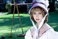 Beautiful woman in vintage Georgian dress and bonnet sitting on lawn in front of stately home. Royalty Free Stock Photo