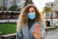 Beautiful woman in virus protection face mask showing gesture Stop Infection