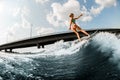 beautiful woman wakesurfer skilfully ride the wave on board at sunny summer day Royalty Free Stock Photo