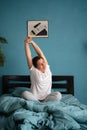 Beautiful woman waking up in morning, stretches in her bed. Happy girl greets new day Royalty Free Stock Photo